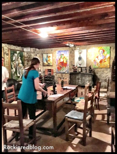 winetasting room below house with art work from each label on the walls 